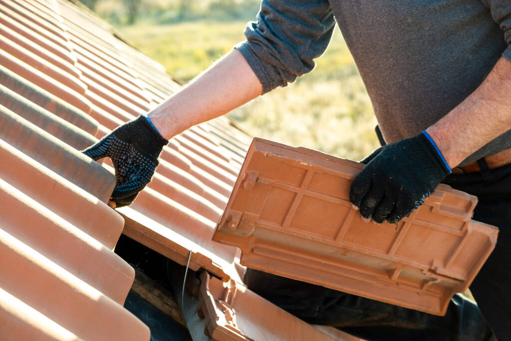 A home improvement professionall installing clay tile roofing