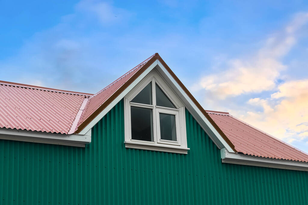 A Cross-Gable roof on a modern home with green siding