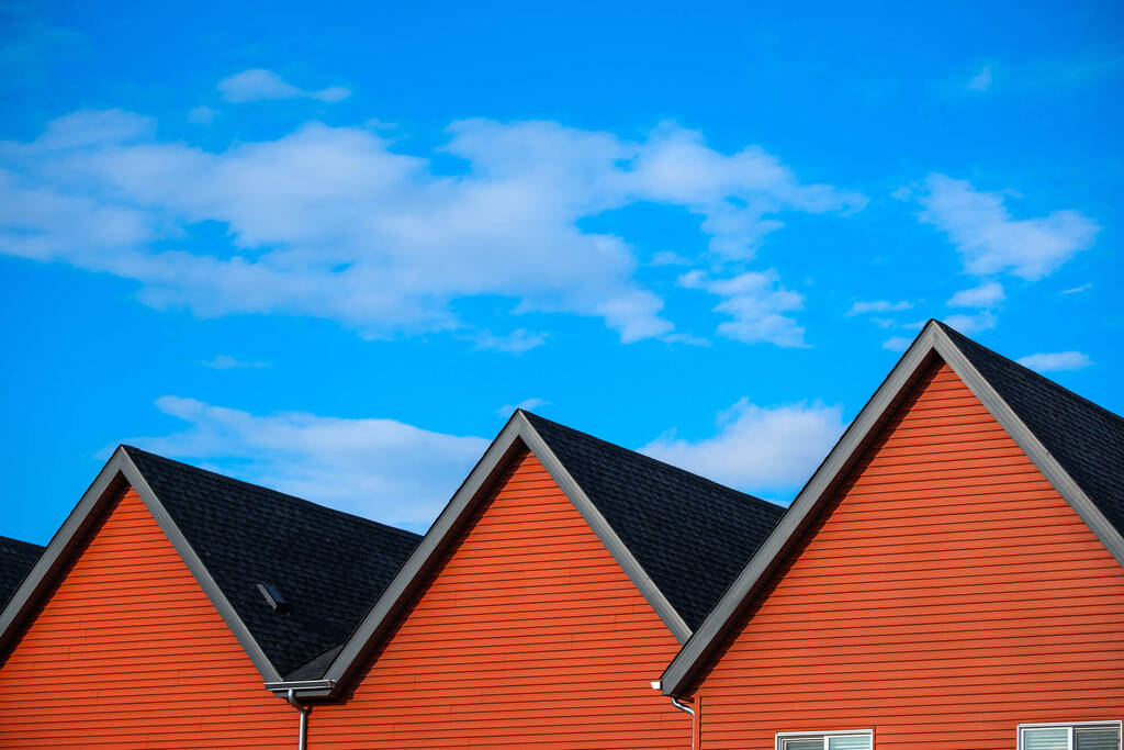Multiple gable roofs shown with a blue sky