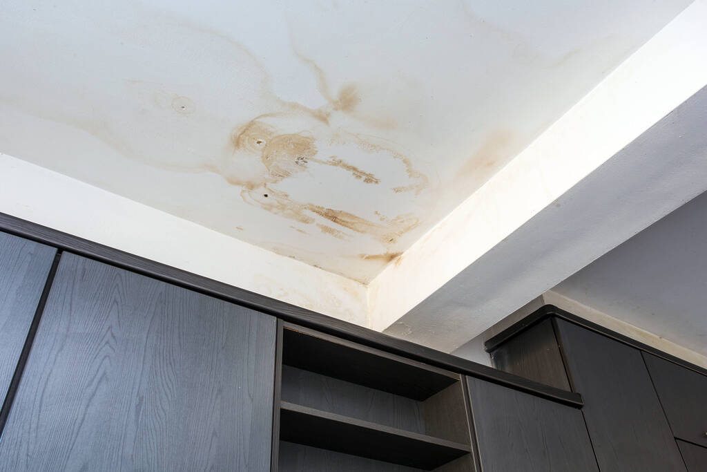 yellow ceiling stain caused by water damage in residential home