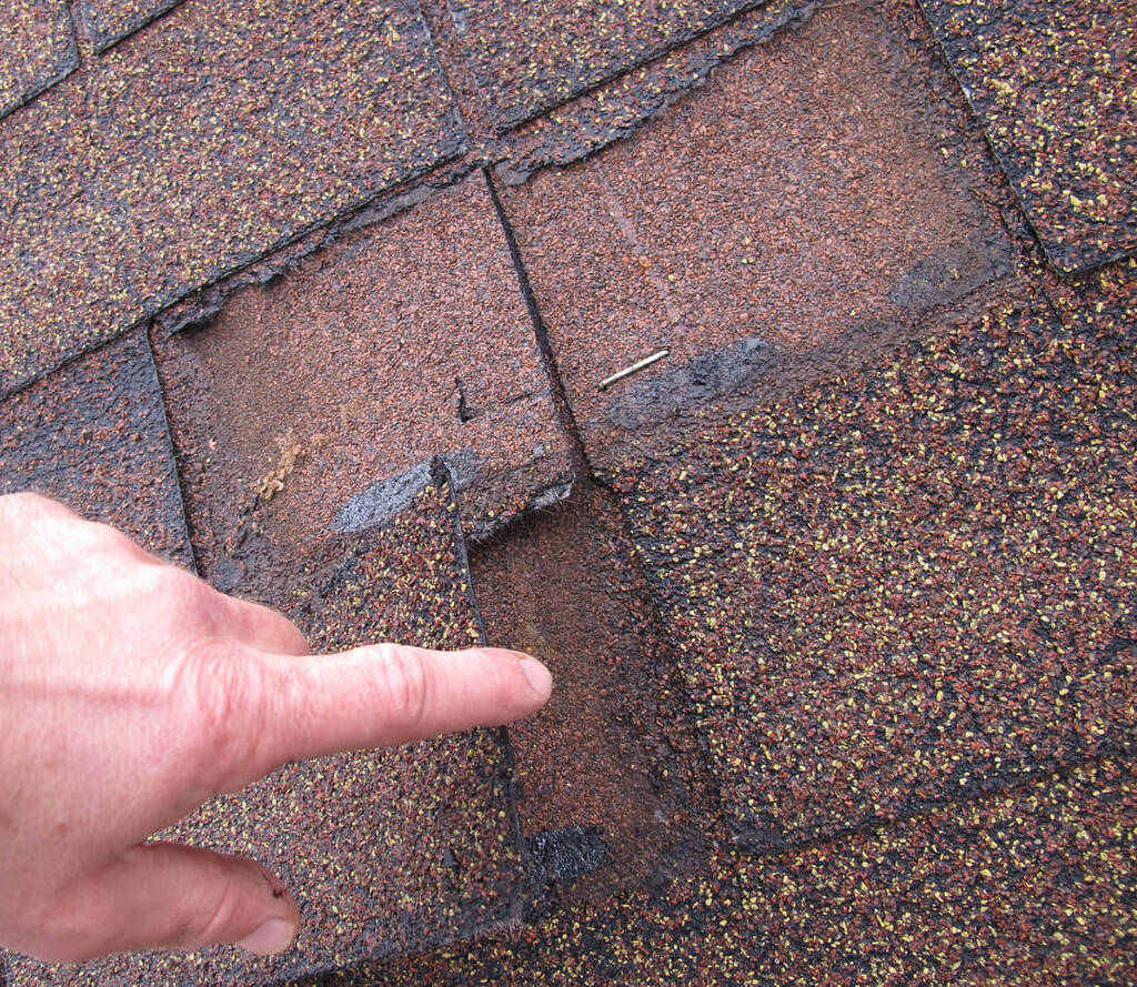 inspecting worn down roof granules